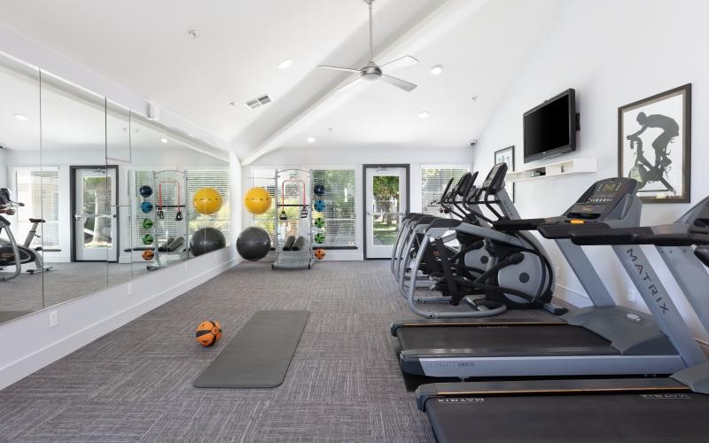 a room with exercise equipment and a tv