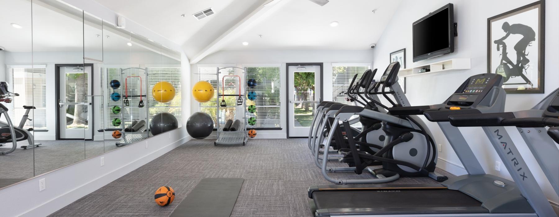 a room with exercise equipment and a tv